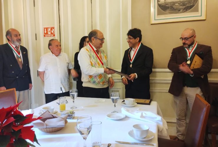 El maestro Raúl Gómez Espinoza entrega reconocimiento al Doctor Eber Omar Betanzos Torres. A la derecha el Maestro Israel González Delgado.